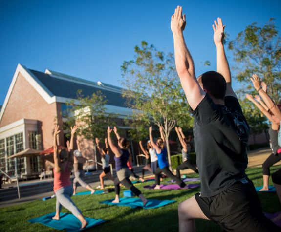 students doing yoga on DUC lawn
